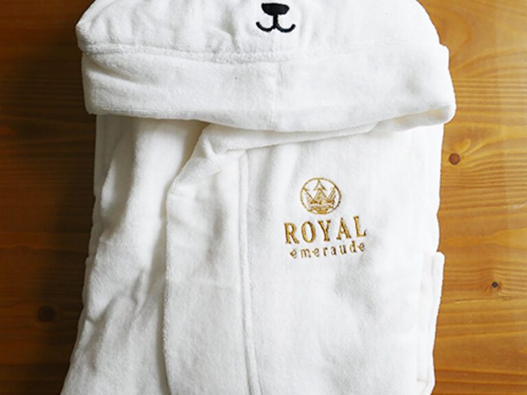 Peignoir blanc avec broderie dorée ROYAL émeraude sur fond en bois