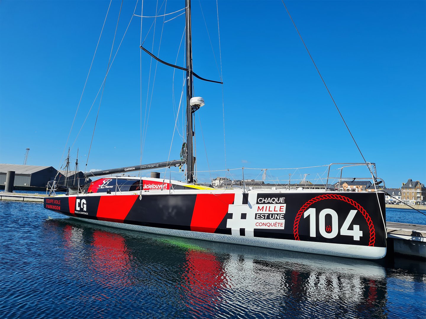 Voilier avec covering marketing affichant le message 'Chaque mille est une conquête'