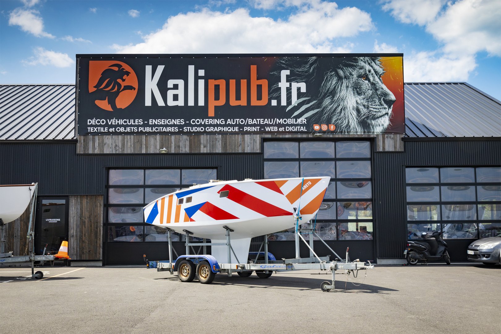 Bateau avec covering coloré devant l'atelier Kalipub.fr