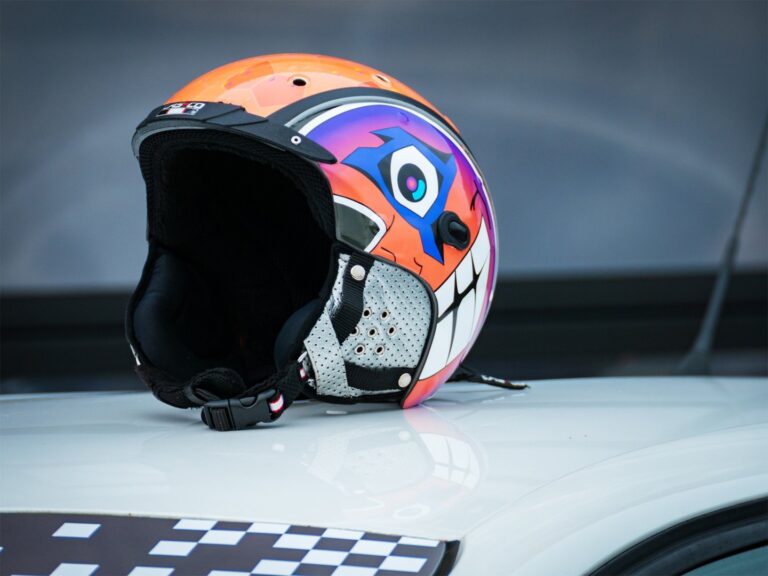 Casque personnalisé avec design coloré posé sur une voiture