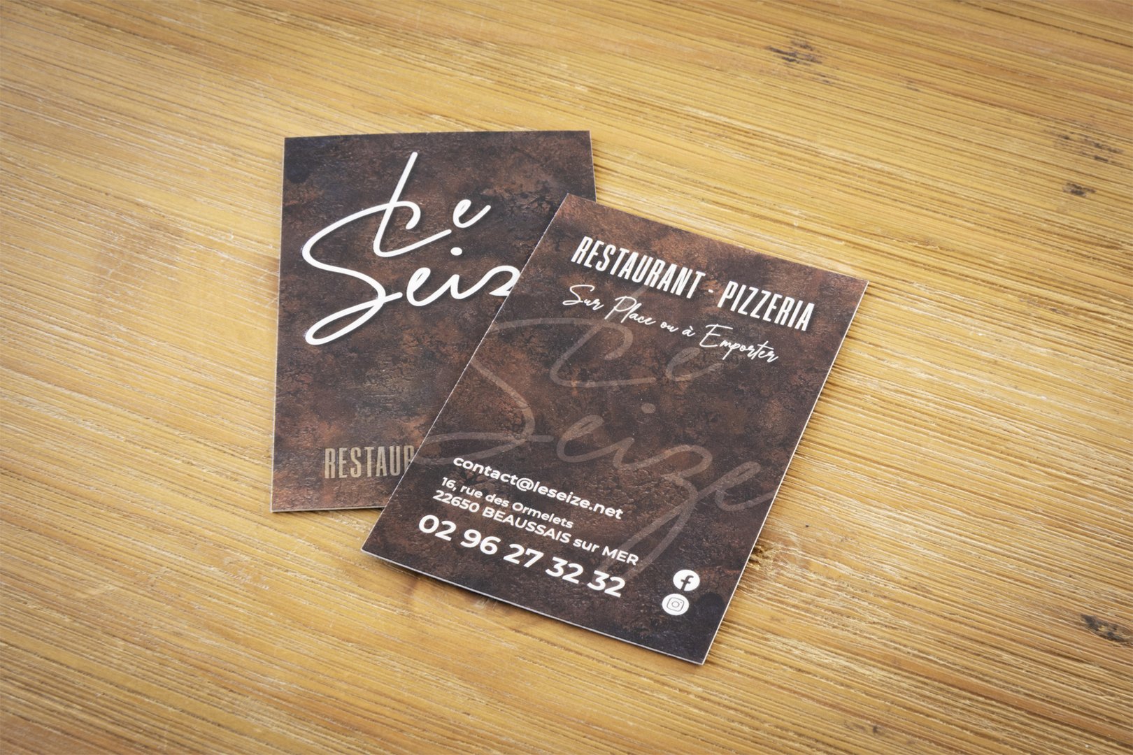 Carte de visite du restaurant Le Seize sur une table en bois.